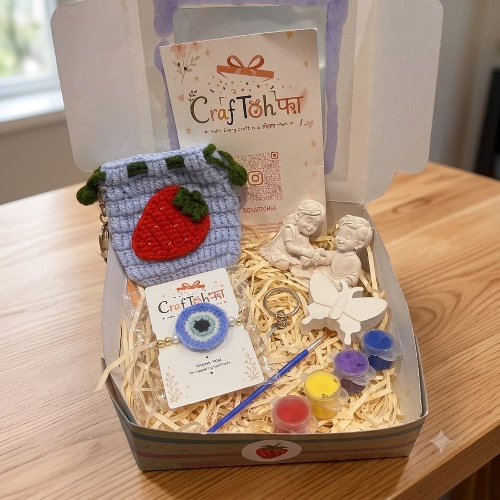 An open combo box with a powder-blue crochet strawberry pouch, a crochet evil eye charm with pearls, an idol and a plaster butterfly with four paint pots and a brush