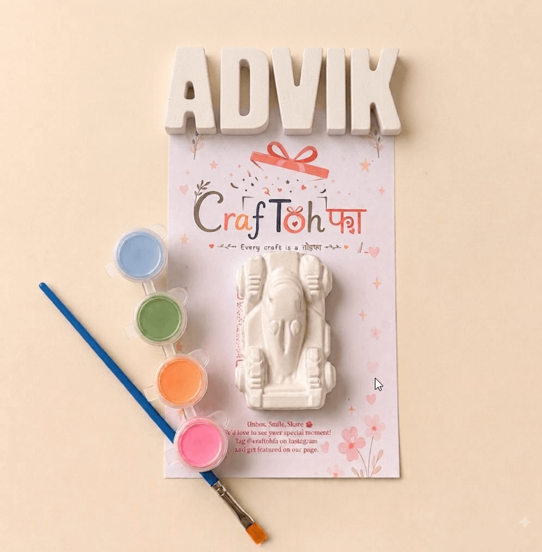 Unpainted plaster letters spelling "ADVIK" above a plaster racing car, with blue, green, orange and pink paint pots and a brush on a printed Craftohfa card