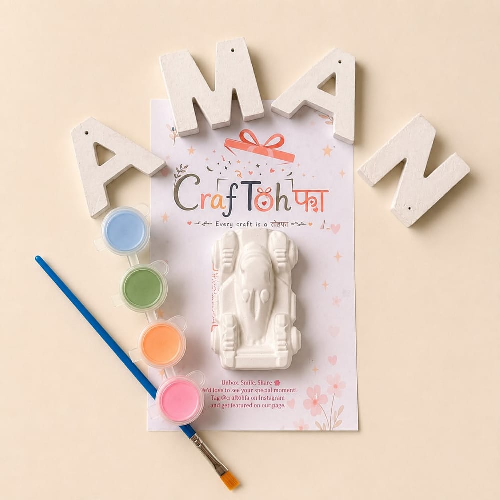 Unpainted plaster letters spelling "AMAN" with a plaster racing car, four paint pots and a brush on a printed Craftohfa card